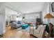 Spacious living room with hardwood floors connecting to a kitchen area and neutral wall colors at 1958 S Pearl St, Denver, CO 80210