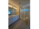 Bathroom with a double sink vanity, neutral color palette, and glass enclosed shower at 490 Grey Rock St, Brighton, CO 80601