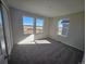 Open bedroom with large windows offering a view of the neighborhood at 490 Grey Rock St, Brighton, CO 80601