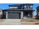 Beautiful two-story home featuring a stone facade, two-car garage, and well-manicured lawn at 490 Grey Rock St, Brighton, CO 80601
