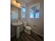 Stylish half bathroom features a pedestal sink and framed window providing natural light at 490 Grey Rock St, Brighton, CO 80601