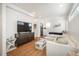 Bright living room with a large TV, light-colored sectional, and hardwood floors at 1260 Newton St # 1, Denver, CO 80204