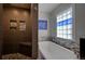 Modern bathroom features a tiled walk-in shower and a luxurious soaking tub with a mosaic tile backsplash at 19563 E Ithaca Pl, Aurora, CO 80013