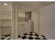 Laundry room with washer, dryer, storage shelves, and black and white checkered floors at 19563 E Ithaca Pl, Aurora, CO 80013