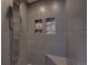 Elegant tiled shower featuring built in soap holders and bench at 19563 E Ithaca Pl, Aurora, CO 80013