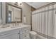 Bathroom featuring a single sink vanity with a toilet and shower behind a shower curtain at 5819 W 82Nd Cir, Arvada, CO 80003