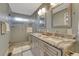 Bathroom featuring a double sink vanity with granite countertops and a walk-in glass shower at 5819 W 82Nd Cir, Arvada, CO 80003