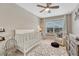 Bright Bedroom featuring a crib, chair, and dresser next to a large window at 5819 W 82Nd Cir, Arvada, CO 80003