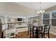 Charming dining area featuring hardwood floors, a modern chandelier, and an open view to the adjacent living room at 5819 W 82Nd Cir, Arvada, CO 80003