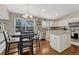 Eat-in kitchen featuring stainless steel appliances, white cabinetry, granite countertops, and hardwood floors at 5819 W 82Nd Cir, Arvada, CO 80003