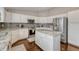 Bright kitchen featuring stainless steel appliances, white cabinets, granite countertops, and stylish backsplash at 5819 W 82Nd Cir, Arvada, CO 80003