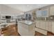 Open-concept kitchen featuring stainless steel appliances, white cabinets, granite countertops, and hardwood floors at 5819 W 82Nd Cir, Arvada, CO 80003