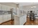 Modern kitchen featuring stainless steel appliances, white cabinetry, granite countertops, and island with seating at 5819 W 82Nd Cir, Arvada, CO 80003