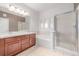 Bright bathroom featuring double sinks, large mirror, and a tiled shower with glass door at 7777 E 23Rd Ave # 1406, Denver, CO 80238