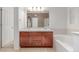 Bathroom features a double sink vanity with wood cabinets, a large mirror, and a soaking tub at 7777 E 23Rd Ave # 1406, Denver, CO 80238