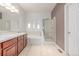 Bathroom featuring double sinks, large mirror, and a tiled shower with glass door at 7777 E 23Rd Ave # 1406, Denver, CO 80238