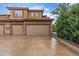 A residence featuring multiple garage doors, a spacious driveway, and verdant landscaping at 7777 E 23Rd Ave # 1406, Denver, CO 80238