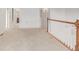 Upstairs hallway with carpet and wood railing, provides an open, airy connection between rooms at 7777 E 23Rd Ave # 1406, Denver, CO 80238