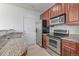 Well lit kitchen with stainless steel appliances, granite countertops and light wood floors at 7777 E 23Rd Ave # 1406, Denver, CO 80238