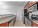 Galley kitchen with stainless steel appliances, granite countertops and natural light at 7777 E 23Rd Ave # 1406, Denver, CO 80238