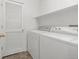 A laundry room with a washer and dryer, white shelving, and a closet with bifold doors at 7777 E 23Rd Ave # 1406, Denver, CO 80238