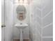 Powder room featuring a pedestal sink, an oval mirror, and patterned wallpaper at 7777 E 23Rd Ave # 1406, Denver, CO 80238