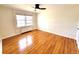 Spacious bedroom with gleaming hardwood floors and a large window providing ample sunlight at 1165 Krameria St, Denver, CO 80220