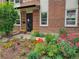 Charming brick home with a beautifully landscaped front yard featuring colorful flowers and lush greenery at 1165 Krameria St, Denver, CO 80220