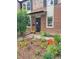 Inviting brick home with a meticulously maintained front yard adorned with vibrant flowerbeds and healthy plants at 1165 Krameria St, Denver, CO 80220