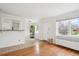 Bright living room featuring hardwood floors, a large window, and an open view to the kitchen at 1165 Krameria St, Denver, CO 80220