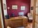 Home office with wood desk, comfortable chair, and burgundy walls at 587 Brookside Dr, Longmont, CO 80504