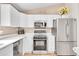 Well-lit kitchen with white cabinetry, stainless steel appliances, and modern countertops at 5162 Hubert St, Parker, CO 80134