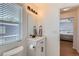 Modern bathroom featuring a white vanity, dark fixtures, a large mirror, and a window for natural light at 4520 Andes St, Denver, CO 80249
