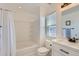 Bathroom featuring a bathtub, shower, white vanity with dark fixtures, and a window for natural light at 4520 Andes St, Denver, CO 80249