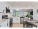 Bright and airy kitchen with white cabinets, stainless appliances, and a view into the open-concept living area at 4520 Andes St, Denver, CO 80249