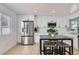 Spacious kitchen with stainless steel appliances, white cabinetry, tile floors, and eat-in breakfast table at 4520 Andes St, Denver, CO 80249