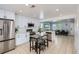 Open concept kitchen with white cabinetry, a breakfast bar, and stainless steel appliances, open to the living room at 4520 Andes St, Denver, CO 80249