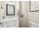 Tastefully decorated half-bathroom featuring an elegant mirror and a white marble vanity at 7812 Inverness Blvd, Englewood, CO 80112