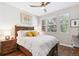 Cozy bedroom with a wood-framed bed, hardwood floors, and bright natural light from three large windows at 7812 Inverness Blvd, Englewood, CO 80112