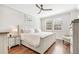 Cozy bedroom with a ceiling fan, hardwood floors, and a large window providing natural light at 7812 Inverness Blvd, Englewood, CO 80112