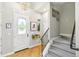 Bright entryway featuring beautiful hardwood floors, a modern chandelier, and staircase leading to the upper level at 7812 Inverness Blvd, Englewood, CO 80112