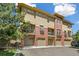 Modern townhome with a brick facade, private balconies, and convenient garage access at 7812 Inverness Blvd, Englewood, CO 80112
