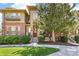 Inviting townhome featuring a well-manicured lawn, brick accents, and a charming front porch area for relaxing at 7812 Inverness Blvd, Englewood, CO 80112