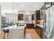 Well-lit kitchen with stainless steel appliances, center island, hardwood floors, and convenient access to the dining area at 7812 Inverness Blvd, Englewood, CO 80112
