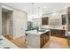 Stunning kitchen featuring modern island, dark wood cabinetry, stainless appliances, and wood flooring at 7812 Inverness Blvd, Englewood, CO 80112