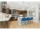 Open kitchen featuring stainless appliances, island with barstool seating, and dark cabinetry with stylish hardware at 7812 Inverness Blvd, Englewood, CO 80112