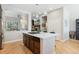 Bright kitchen features a center island with a cooktop and modern pendant lights, plus hardwood floors at 7812 Inverness Blvd, Englewood, CO 80112