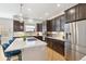 Gorgeous kitchen boasting dark cabinets, a stainless fridge, and a bright countertop island with pendant lighting at 7812 Inverness Blvd, Englewood, CO 80112