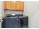 Convenient laundry room with upper cabinets and modern washer and dryer at 7812 Inverness Blvd, Englewood, CO 80112