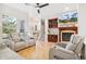 Bright and airy living room features hardwood floors, a fireplace, built-in shelves and easy access to the entryway at 7812 Inverness Blvd, Englewood, CO 80112